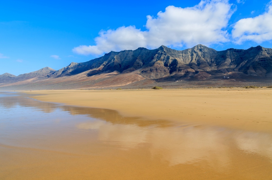 'Reflection of mountains in wet sand on Cofete beach in secluded part of Fuerteventura, Canary Islands, Spain' - Canarische Eilanden